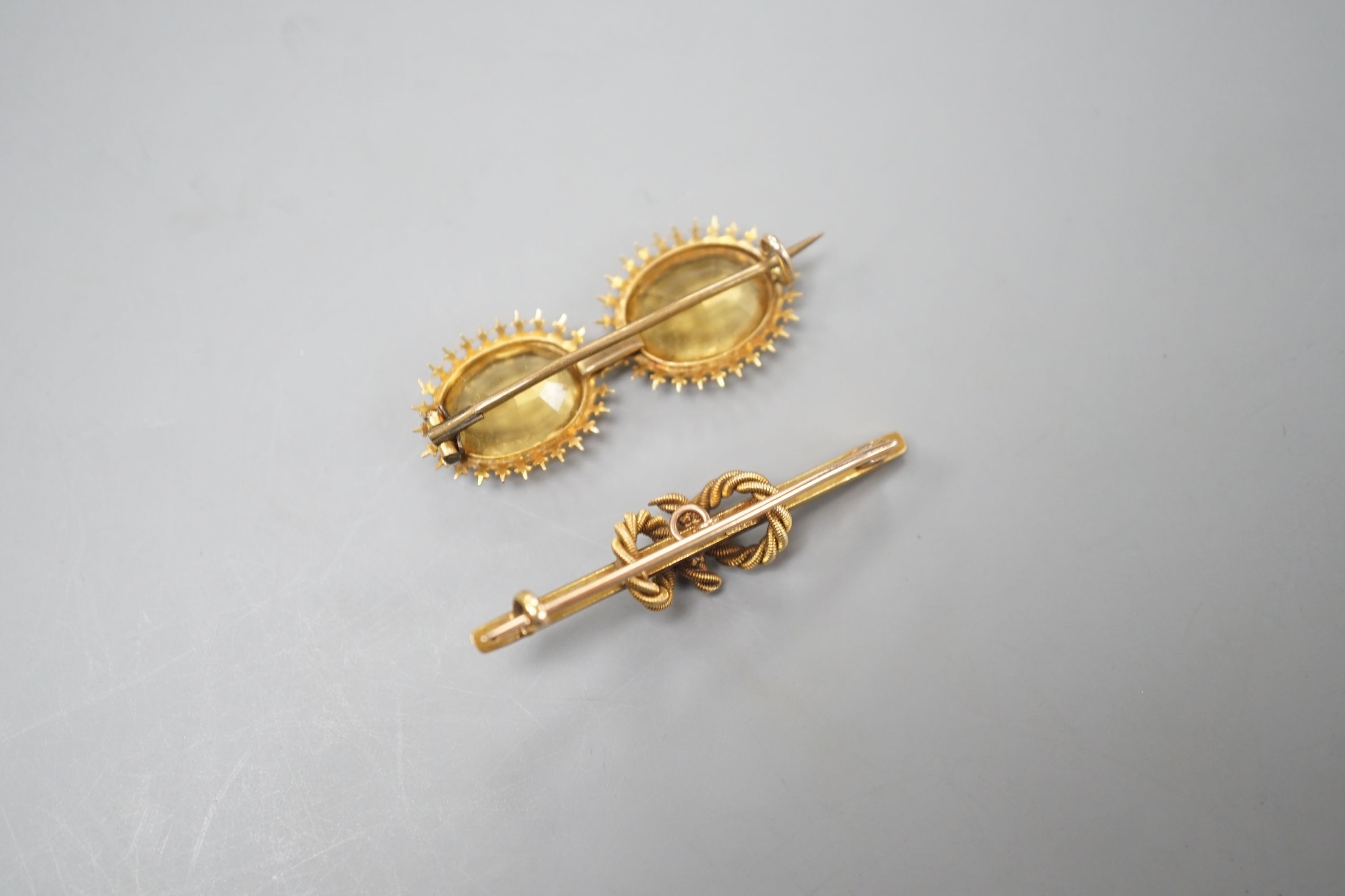 An Edwardian 15ct and seed pearl set rope twist bar brooch, 42mm and a yellow metal and two stone citrine set bar brooch, gross weight 8.3 grams.